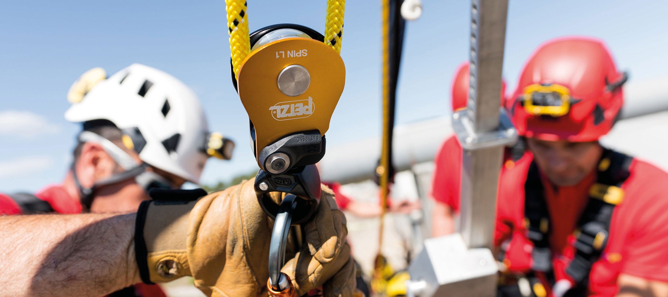 Two people in safety gear with a PETZL pulley system.