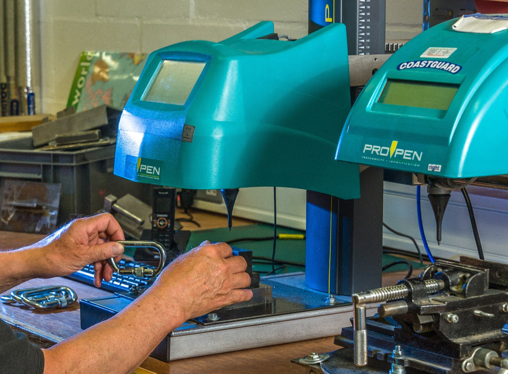 Two teal ProTape dispensers with digital displays on a workbench.