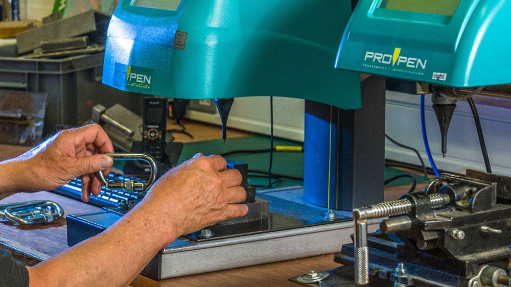 Two teal ProTape dispensers with digital displays on a workbench.
