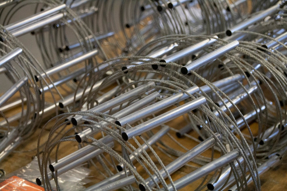 Metal bike racks with cables on a wooden floor