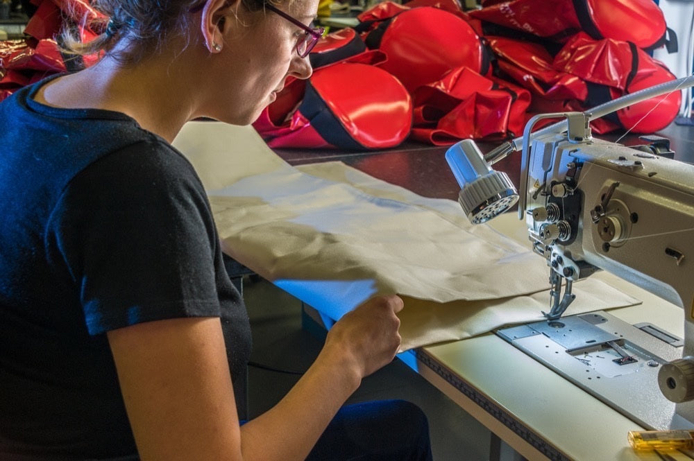 Person working with fabric at a sewing machine in a workshop setting