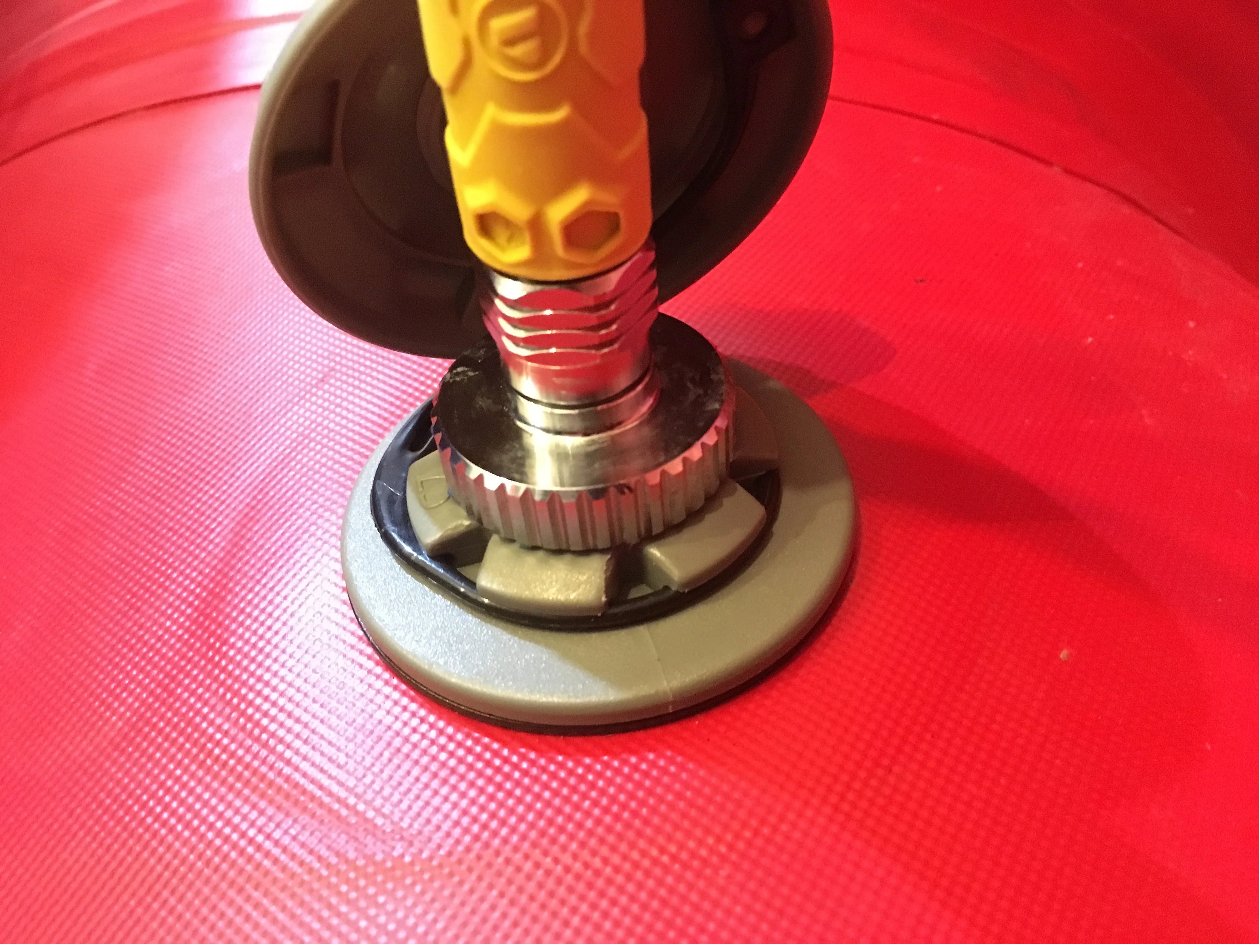 Close-up of a spray gun nozzle on a red background