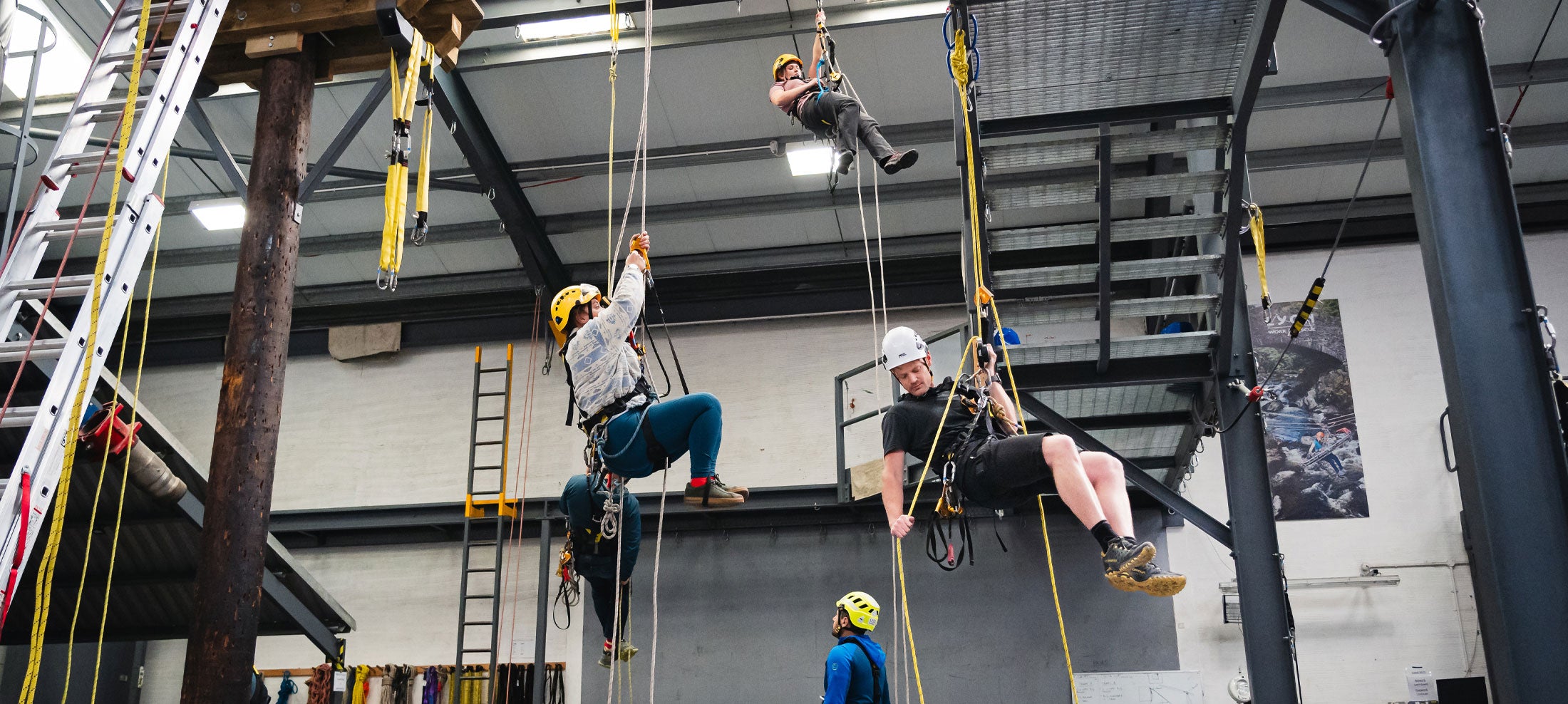 People participating in a ropes course inside a building