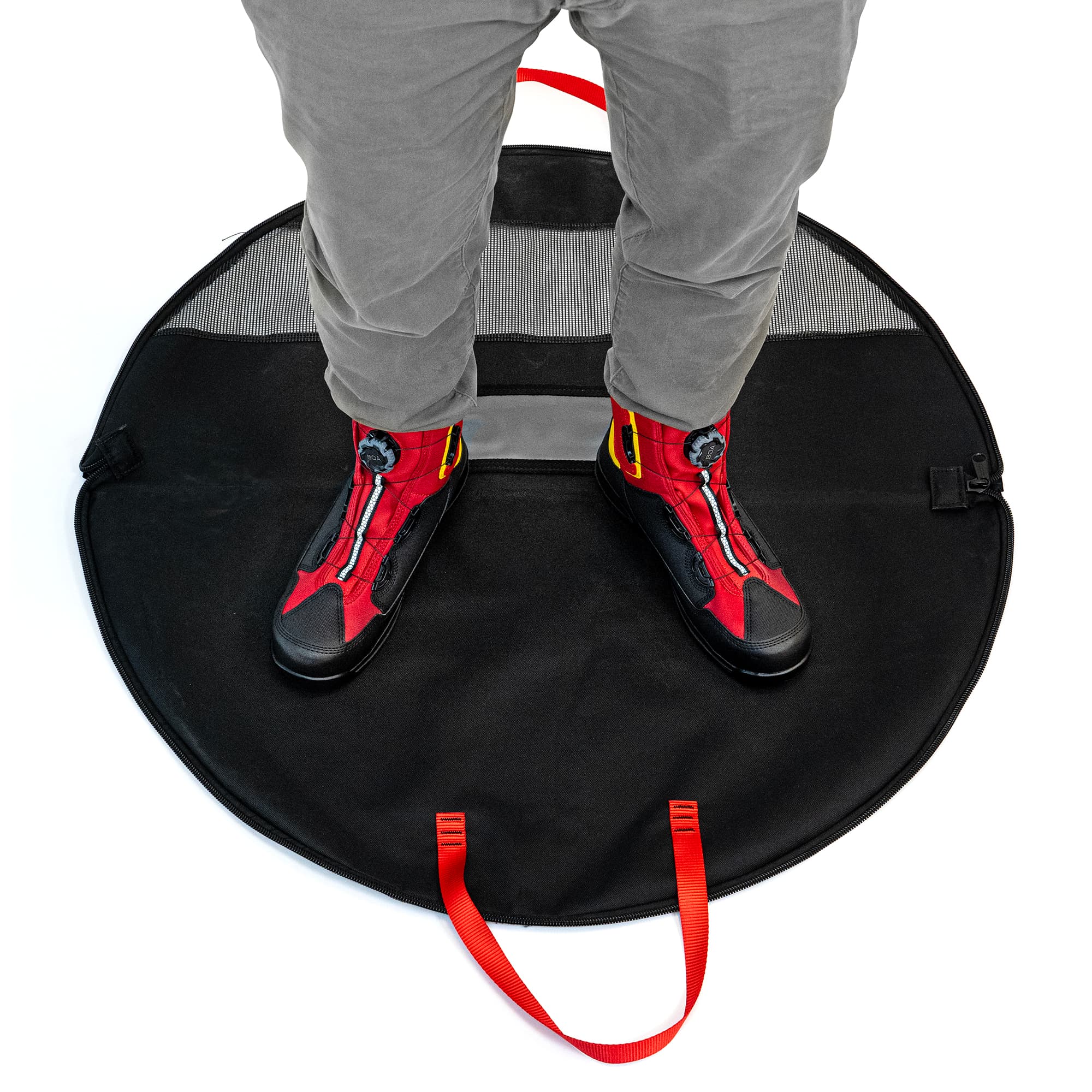 Person wearing red and black shoes stepping onto a black mat with red handles.