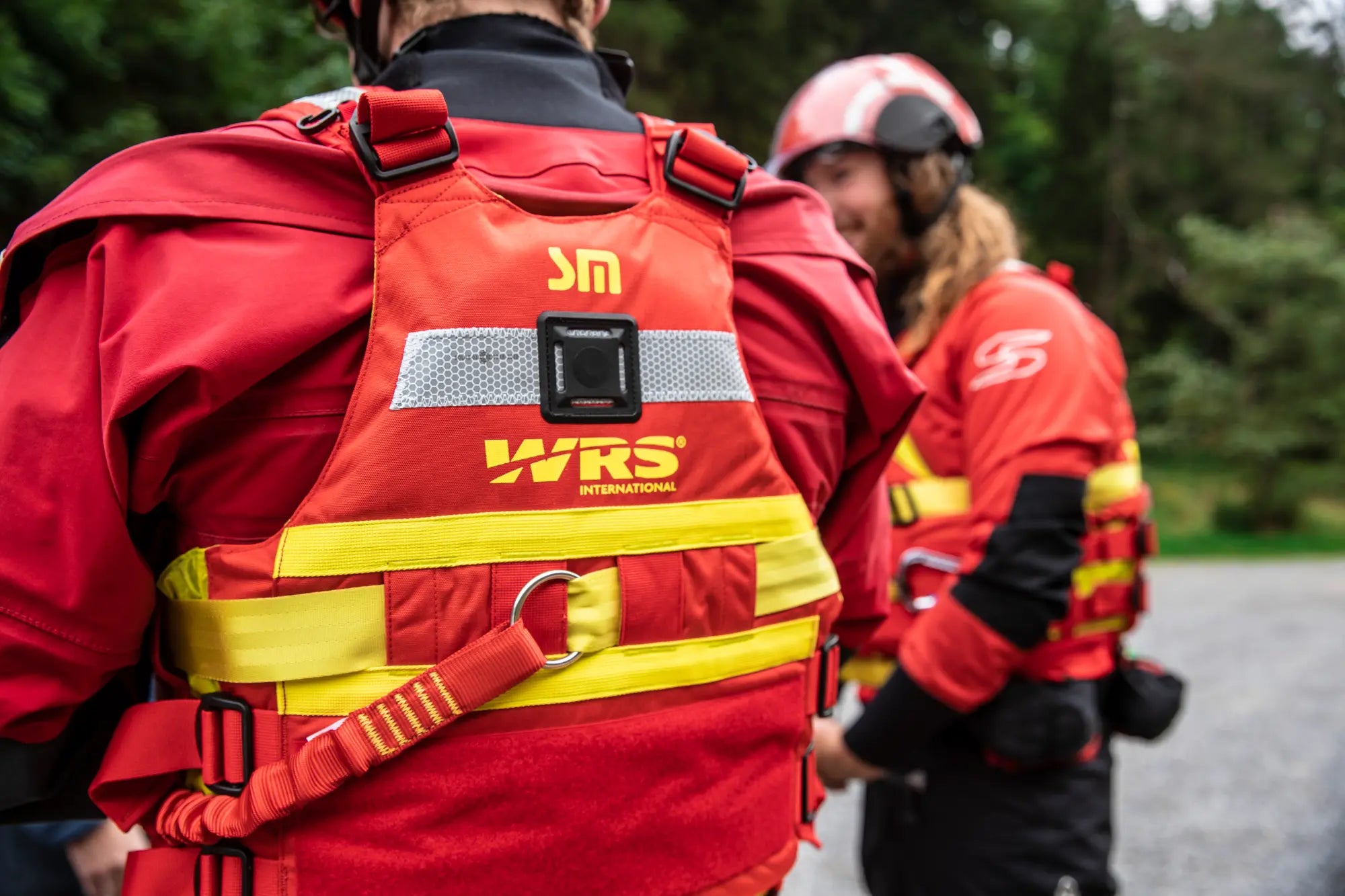 Person wearing a red WRS life jacket with another person in the background.