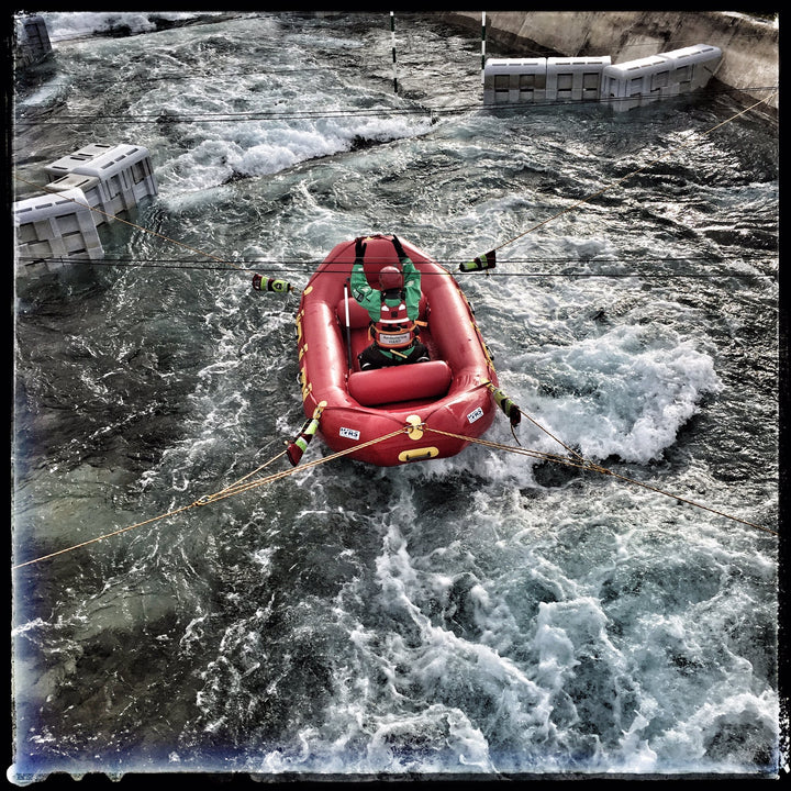 Red inflatable raft in turbulent water with a person inside