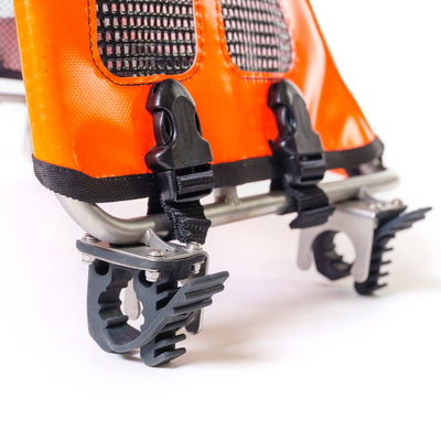 Close-up of orange ski boot with metal crampons on a white background
