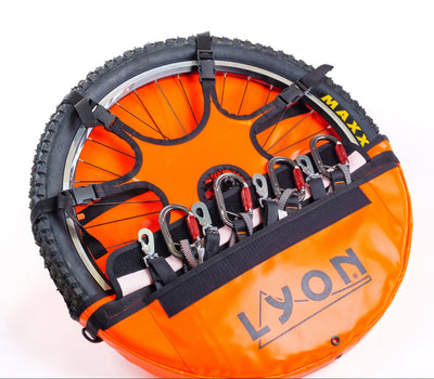 Orange tire with straps and carabiners on a white background