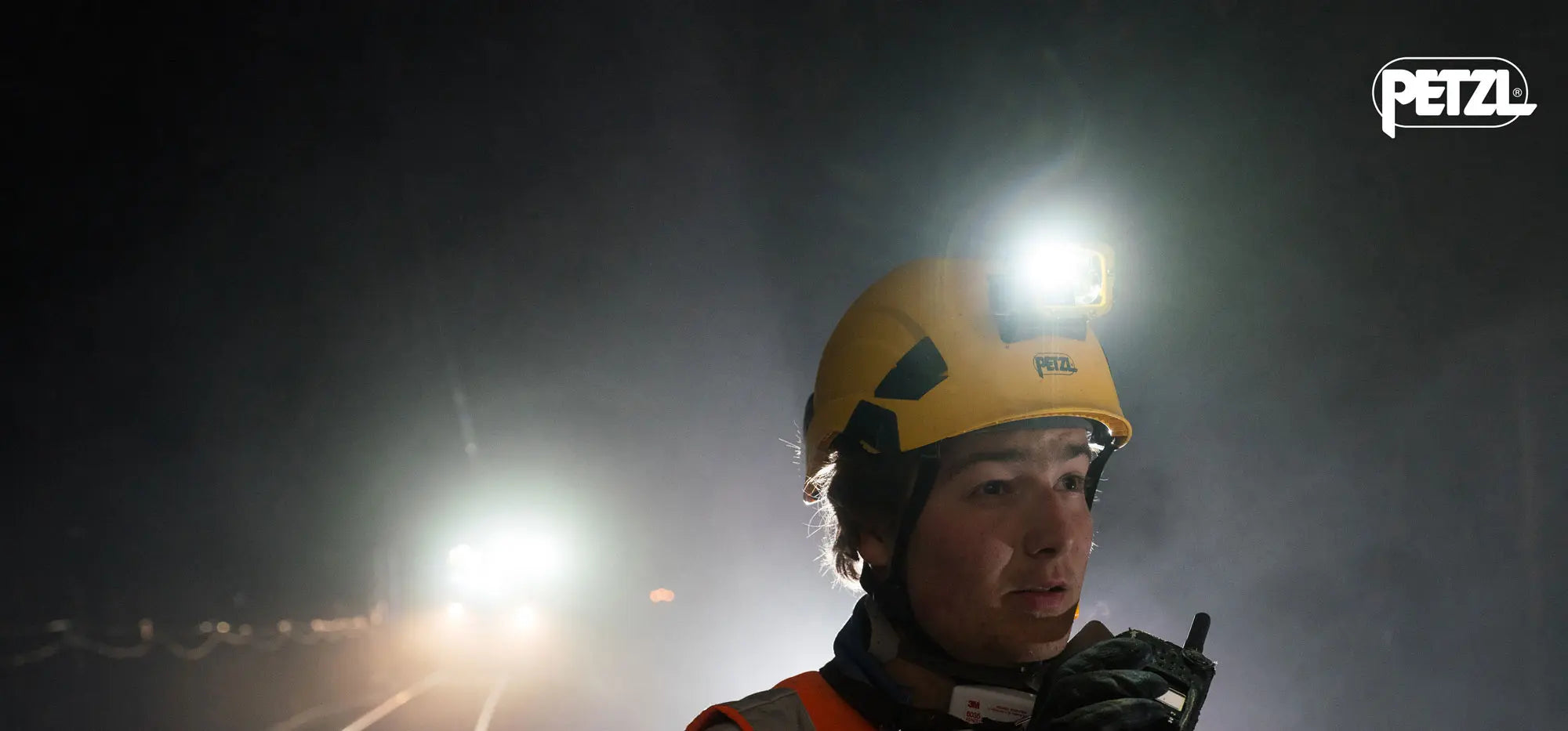 Person wearing a helmet with a light source in a dark environment, with 'PETZL' branding.
