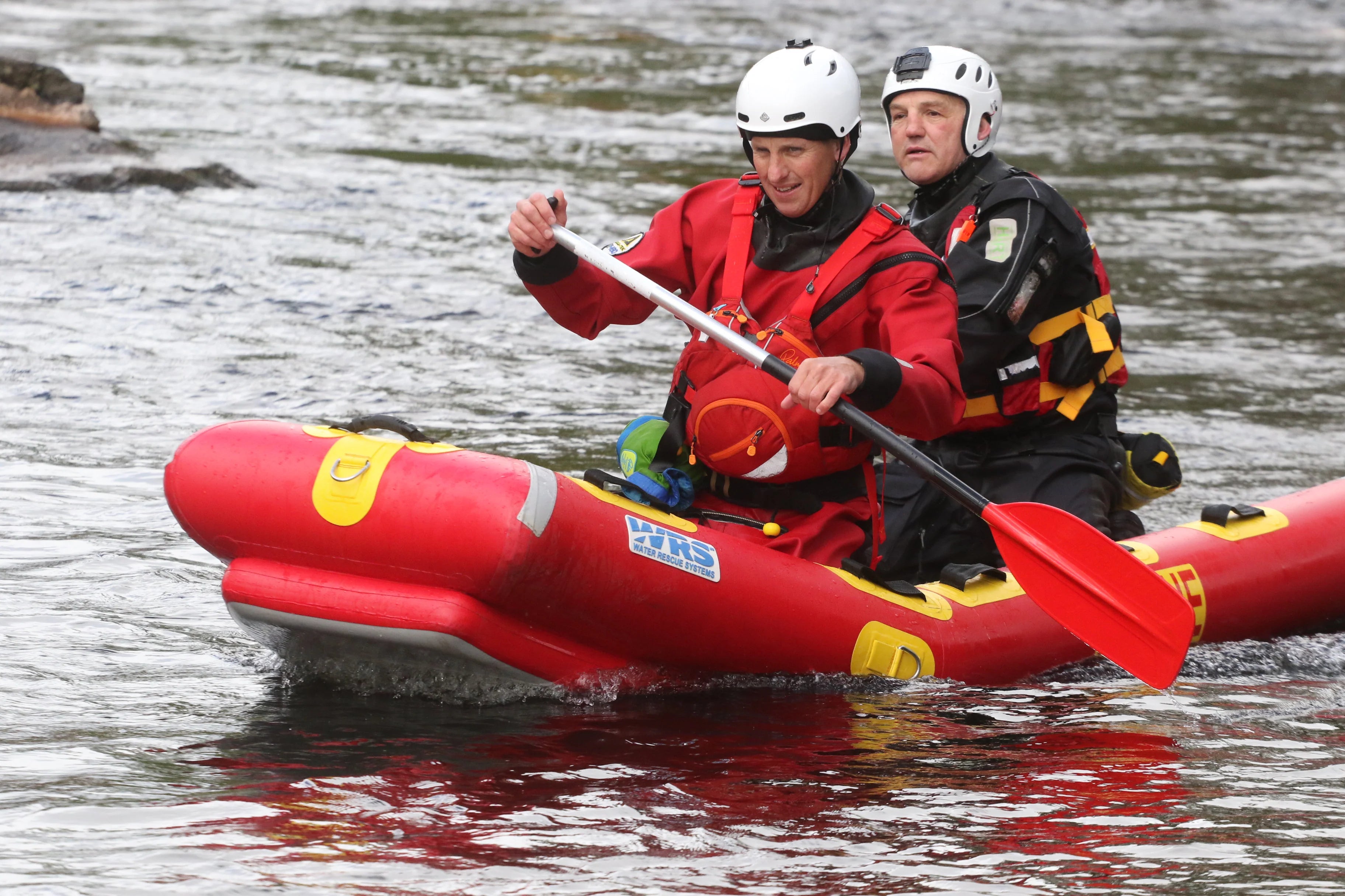 Two people in a red inflatable kayak on water